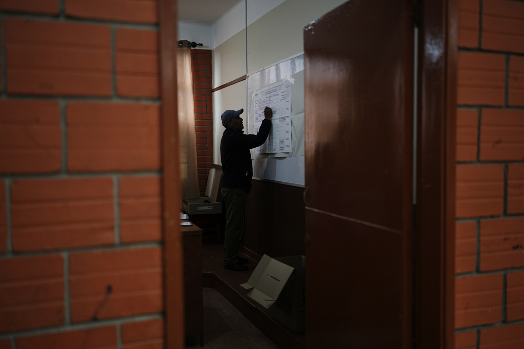 An electoral official records votes on a board after polls closed during a presidential runoff election in La Paz, Bolivia, Sunday, Oct. 19, 2025. (AP Photo/Ivan Valencia)