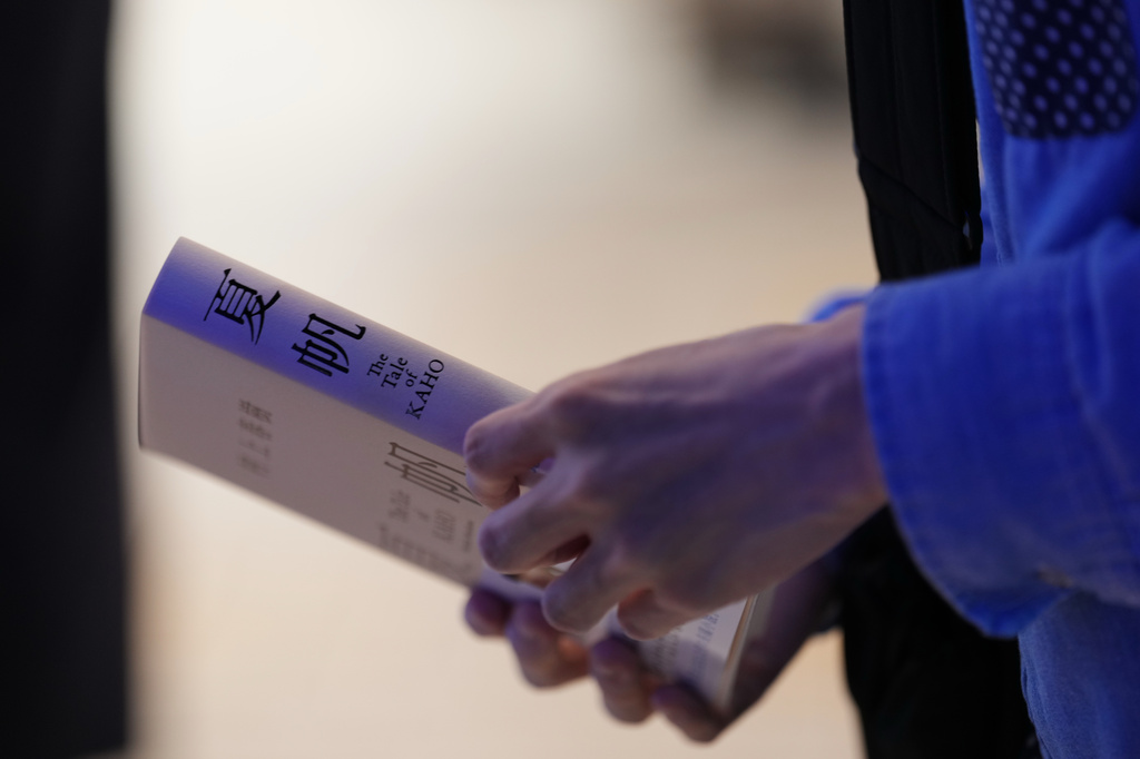 Naoyuki Yamano holds his copy of Haruki Murakami's new book titled "The Tale of KAHO," which he pre-purchased and received after the clock struck midnight during a countdown event at a Kinokuniya bookstore in Tokyo, Friday, July 3, 2026. (AP Photo/Hiro Komae)