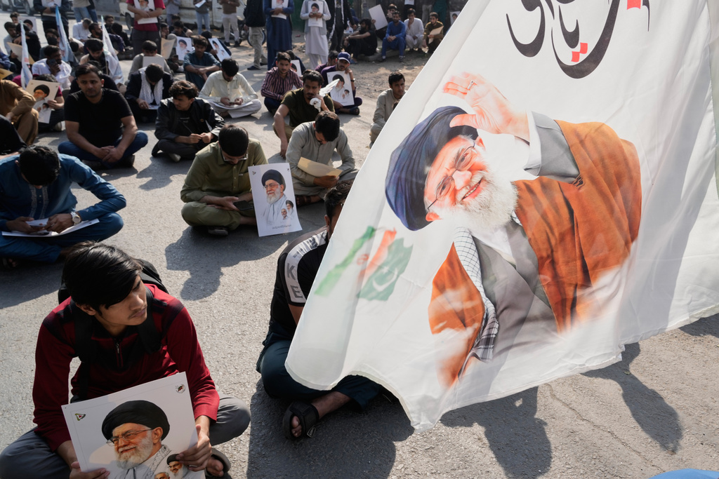 Pakistani Shiite Muslims sit on a road during a demonstration to condemn the death of Iranian Supreme Leader Ayatollah Ali Khamenei in a major attack by Israel and the United States, in Lahore, Pakistan, Sunday, March 1, 2026. (AP Photo/K.M. Chaudary)