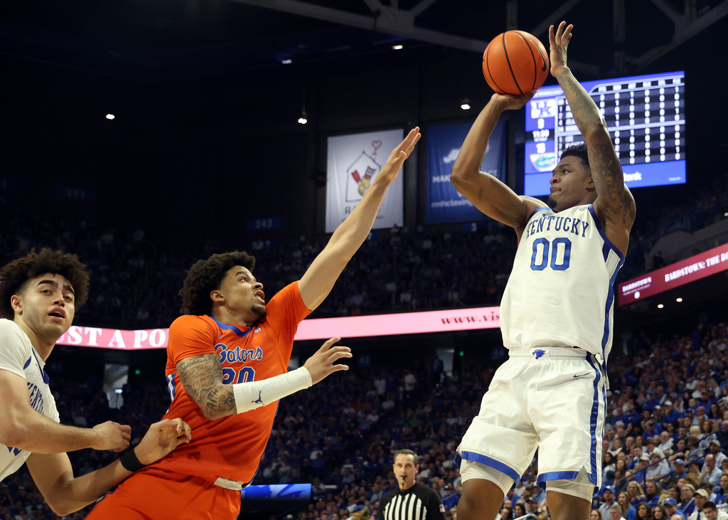 Kentucky's Otega Oweh (00) looks to shoot while pressured by Florida's Isaiah Brown, second from left, during the first half of an NCAA college basketball game in Lexington, Ky., Saturday, March 7, 2026. (AP Photo/James Crisp)