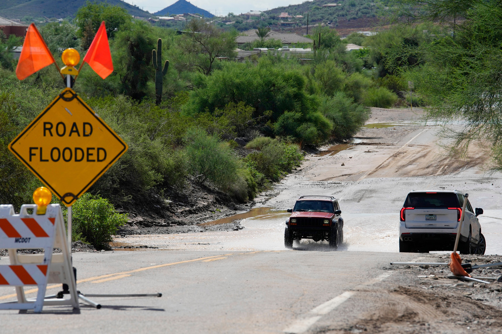 Vehicles navigate on a road after torrential rains moved through the Phoenix metro area, Tuesday, Sept. 29, 2026, in Anthem, Ariz. (AP Photo/Ross D. Franklin)