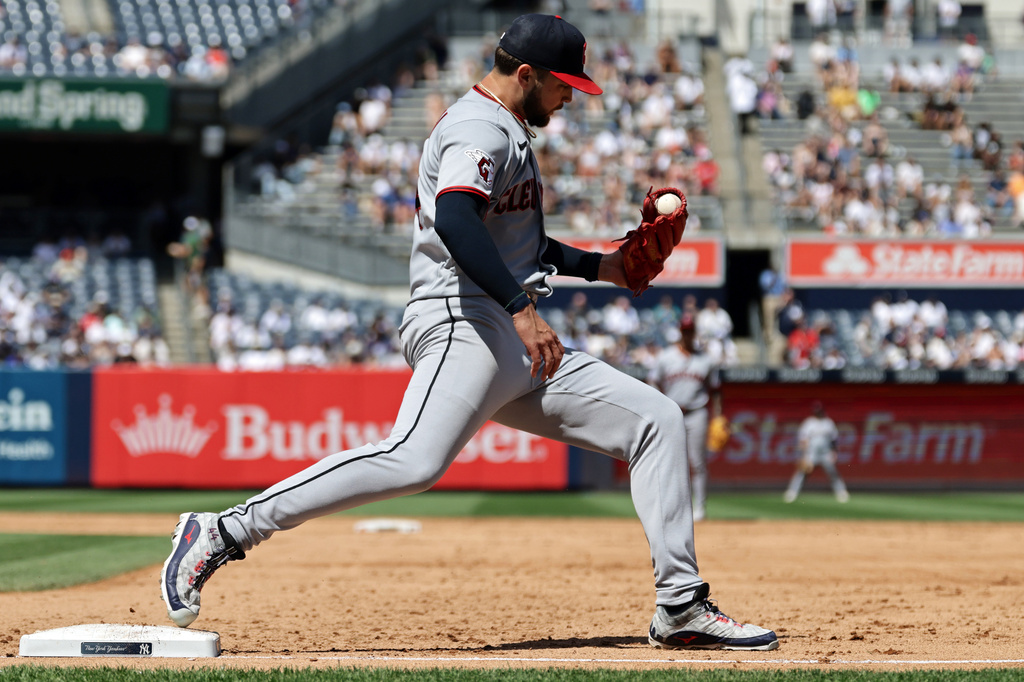 Cleveland Guardians pitcher Slade Cecconi checks his glove for the ball after getting a force out on New York Yankees' Ryan McMahon at first base during the fifth inning of a baseball game Thursday, June 4, 2026, in New York. (AP Photo/Adam Hunger)
