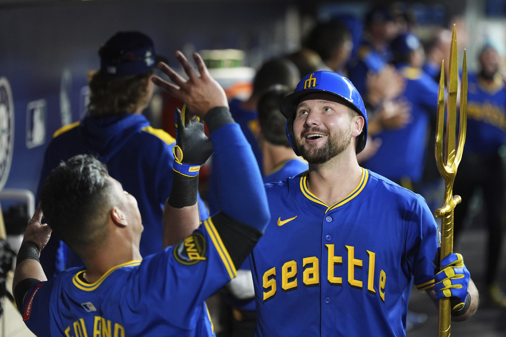 Seattle Mariners' Cal Raleigh celebrates his three-run home run against the Tampa Bay Rays with teammate Donovan Solano, left, during the eighth inning of a baseball game Friday, Aug. 8, 2025, in Seattle. (AP Photo/Lindsey Wasson)