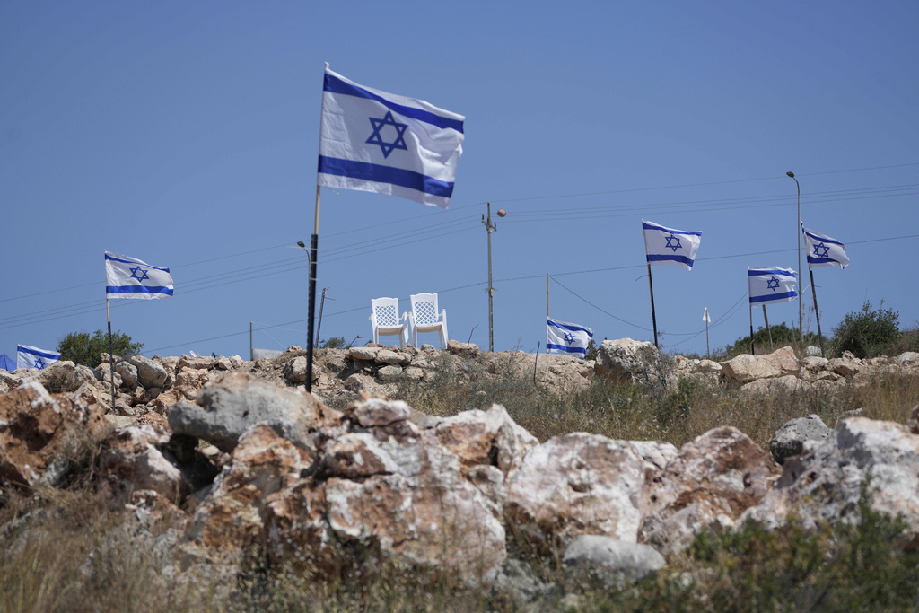 FILE - Israeli flags flutter on top of a hill that is adjacent to Palestinian properties that were under attack by Israeli settlers overnight, leaving several burnt vehicles and damaged homes, residents said, in the West Bank village of Bruqin, near Salfit, Friday, May 23, 2025. (AP Photo/Nasser Nasser, File)