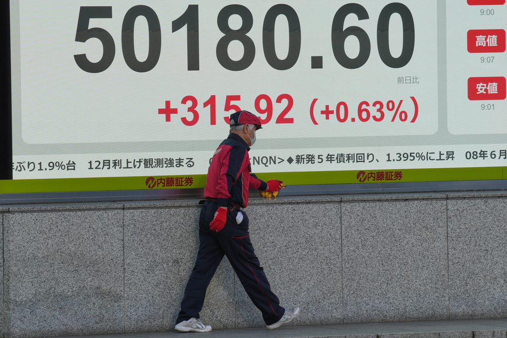 A staff cleans an electronic stock board showing Japan's Nikkei index at a securities firm Thursday, Dec. 4, 2025, in Tokyo. (AP Photo/Eugene Hoshiko)