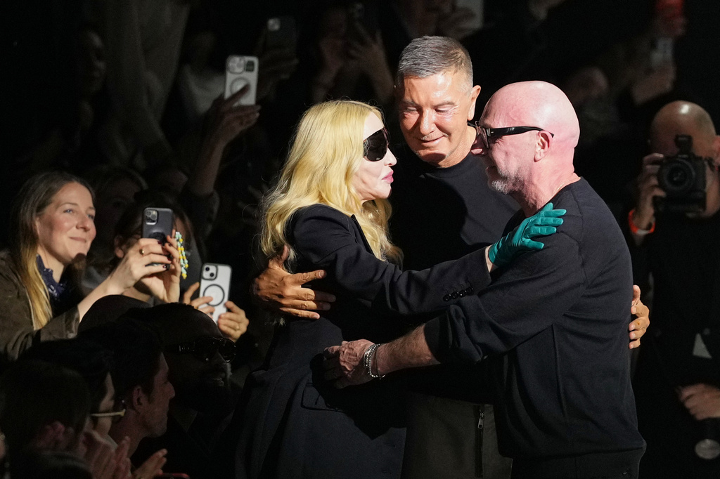 FILE -Madonna congratulates Domenico Dolce, right, and Stefano Gabbana at the end of the Dolce & Gabbana Fall/Winter 2026-2027 Women's collection, presented in Milan, Italy, Feb. 28, 2026. (AP Photo/Antonio Calanni), File)
