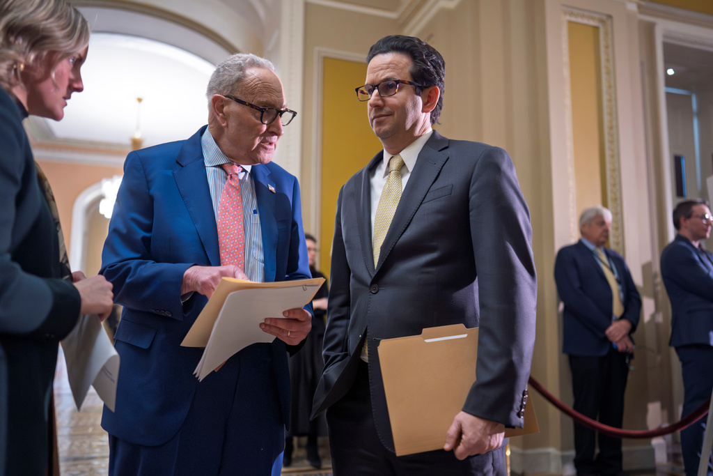 Senate Minority Leader Chuck Schumer, D-N.Y., center, confers with Sen. Brian Schatz, D-Hawaii, talk following a Senate Democratic Caucus meeting, at the Capitol in Washington, Tuesday, Feb. 3, 2026. (AP Photo/J. Scott Applewhite)