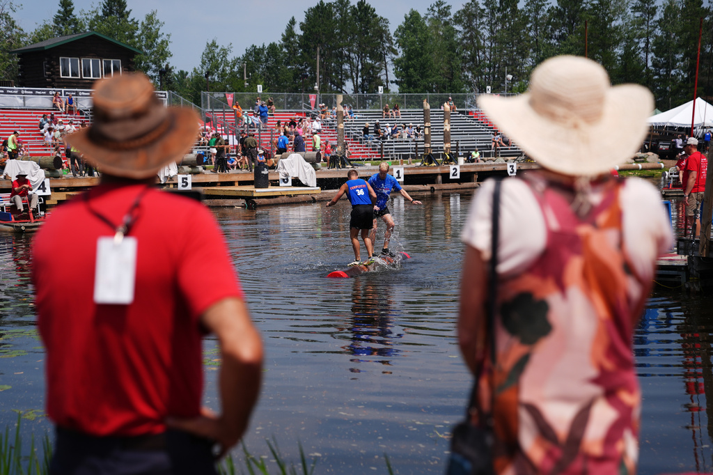 Spectators watch a men's log rolling heat during the Lumberjack World Championships, Saturday, July 18, 2026, in Hayward, Wis. (AP Photo/Ellen Schmidt)