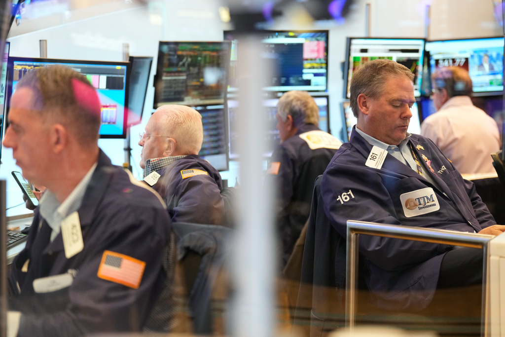 Traders, including Thomas McCauley, second from right, work on the floor at the New York Stock Exchange in New York, Wednesday, Oct. 29, 2025. (AP Photo/Seth Wenig)