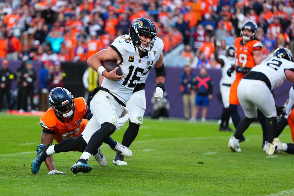 Jacksonville Jaguars quarterback Trevor Lawrence (16) runs with the ball during the second half of an NFL football game against the Denver Broncos in Denver, Sunday, Dec. 21, 2025. (AP Photo/Jack Dempsey)