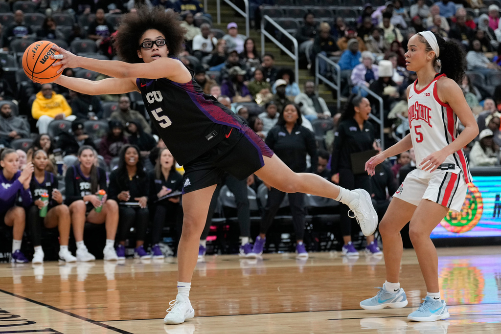 TCU's Olivia Miles, left, keeps the ball from going out-of-bounds while Ohio State's Ava Watson looks on during the first half of an NCAA women's college basketball game in Newark, N.J., Monday, Jan. 19, 2026. (AP Photo/Seth Wenig)