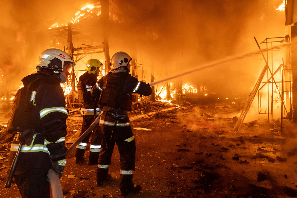 Firefighters tackle the blaze after a Russian air attack that hit at Barabashovo market in Kharkiv, Ukraine, Wednesday, Oct. 1, 2025. (AP Photo/Andrii Marienko)