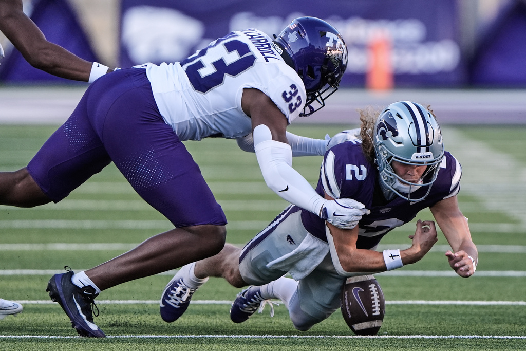 Kansas State quarterback Avery Johnson (2) recovers his own fumble for a first down as he is tackled by TCU linebacker Max Carroll (33) during the second half of an NCAA college football game Saturday, Oct. 11, 2025, in Manhattan, Kan. (AP Photo/Charlie Riedel)