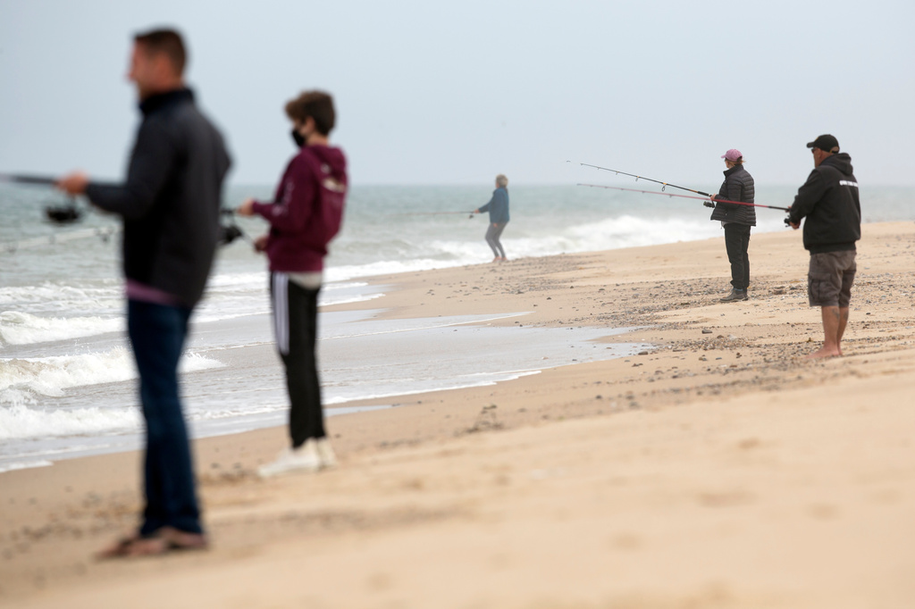 FILE - People fish on Race Point Beach, part of Cape Cod National Seashore, May 25, 2020, in Provincetown, Mass. (AP Photo/Michael Dwyer, File)