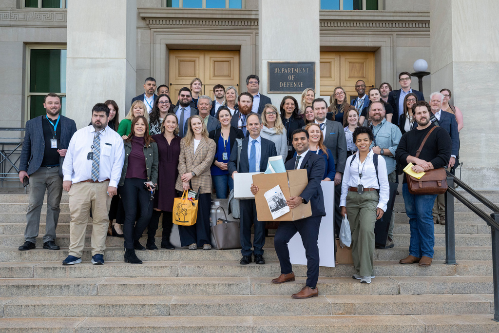 Members of the Pentagon press corp gather for a group photo after turning in their press credentials, Wednesday, Oct. 15, 2025 in Washington. (AP Photo/Kevin Wolf)