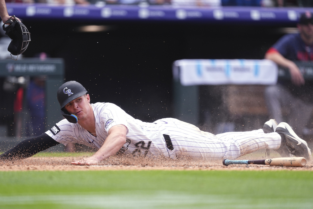 Colorado Rockies' Mickey Moniak scores on a bunt put down by Tyler Freeman in the eighth inning of a baseball game against the Boston Red Sox Wednesday, June 24, 2026, in Denver. (AP Photo/David Zalubowski)
