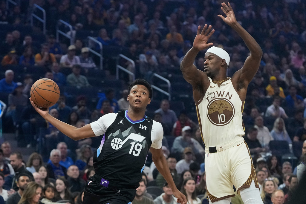 Utah Jazz forward Ace Bailey (19) drives to the basket against Golden State Warriors forward Jimmy Butler III (10) during the first half of an NBA basketball game in San Francisco, Monday, Nov. 24, 2025. (AP Photo/Jeff Chiu)