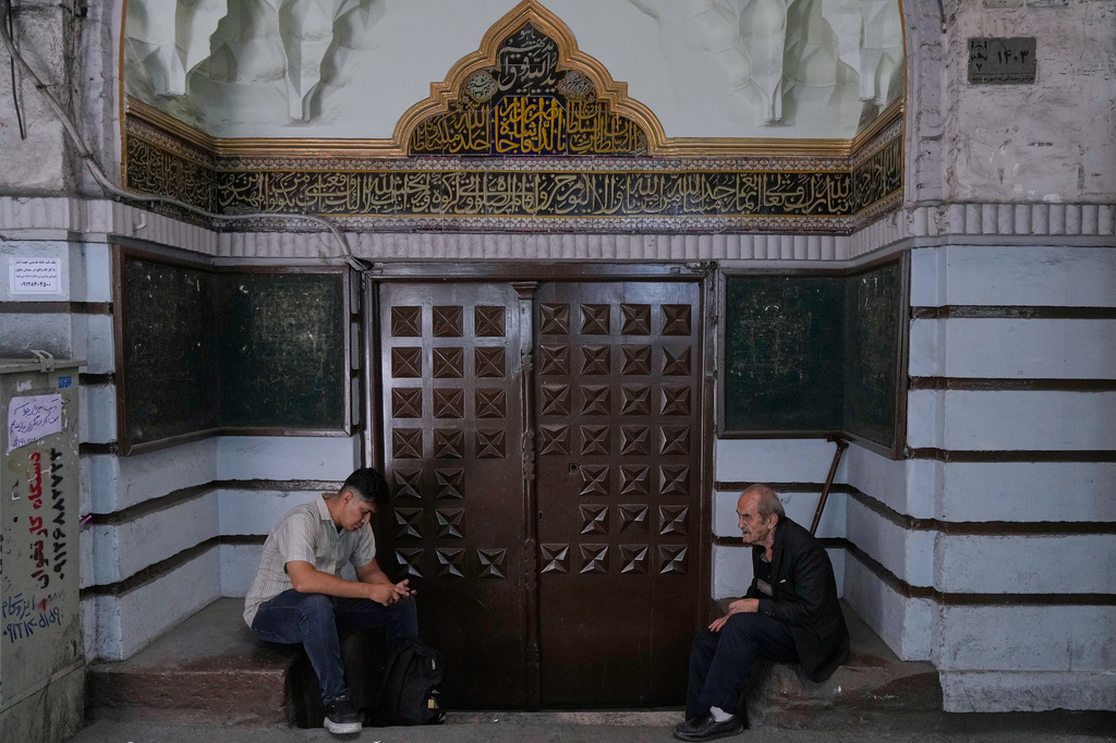 Men sit at the gate of a mosque at Tehran's historic Grand Bazaar, Iran, Monday, June 1, 2026. (AP Photo/Vahid Salemi)