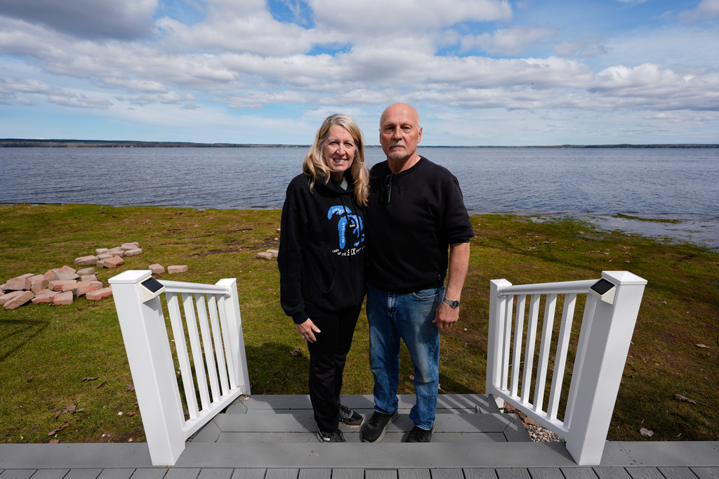 Tom and Diane Peterman pose outside their home at Black Lake on Wednesday, April 29, 2026, in Grant Township, Mich. (AP Photo/Paul Sancya)