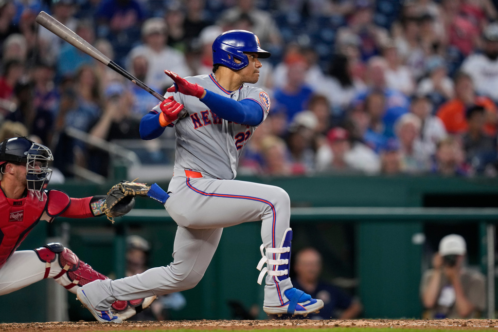 New York Mets designated hitter Juan Soto, right, follows through his swing as he hits a two-RBI single against the Washington Nationals during the fifth inning of a baseball game, Monday, May 18, 2026, in Washington. (AP Photo/Jess Rapfogel)