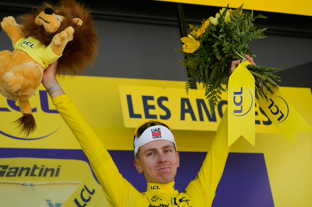 Slovenia's Tadej Pogacar wearing the overall leader's yellow jersey celebrates on the podium after winning the third stage of the Tour de France cycling race with start in Granollers and finish in Les Angles , France, Monday, July 6, 2026. (AP Photo/Mosa'ab Elshamy)