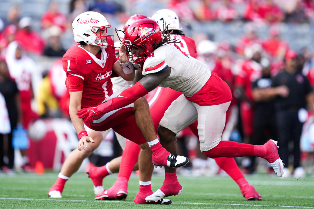 Houston quarterback Conner Weigman (1) is hit by Arizona linebacker Max Harris (4) during the first half of an NCAA college football game, Saturday, Oct. 18, 2025, in Houston. (Jason Fochtman/Houston Chronicle via AP)