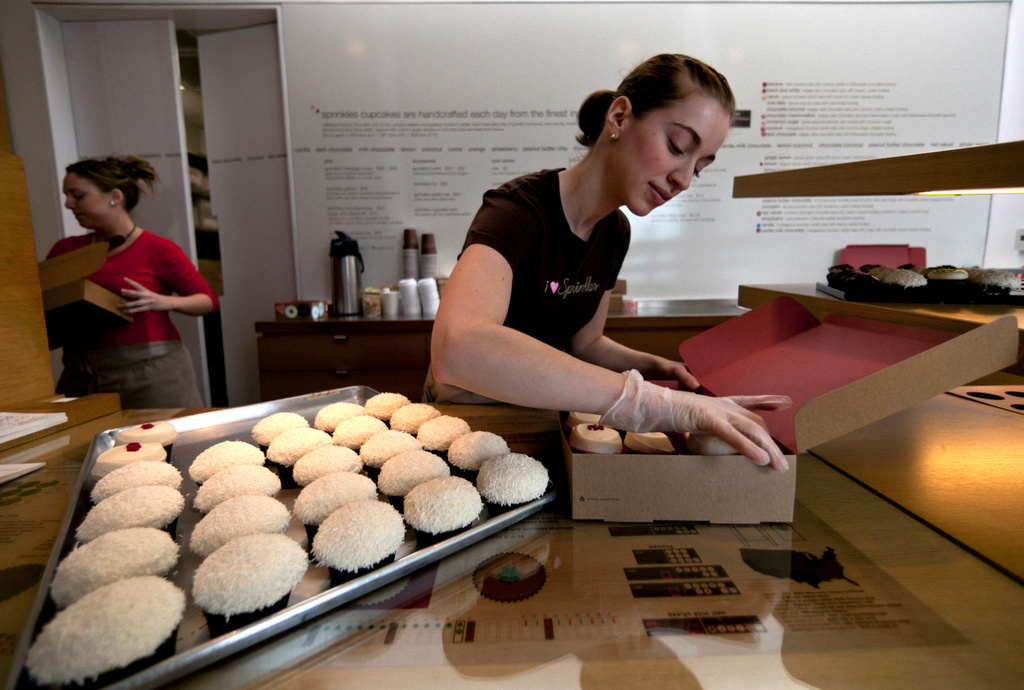 FILE - Sara Cebulski arranges a custom box of cupcakes at Sprinkles, where a 24-Hour Cupcake "ATM," will be continuously restocked to dispense fresh cupcakes, in Beverly Hills, Calif., March 5, 2012. (AP Photo/Damian Dovarganes, File)