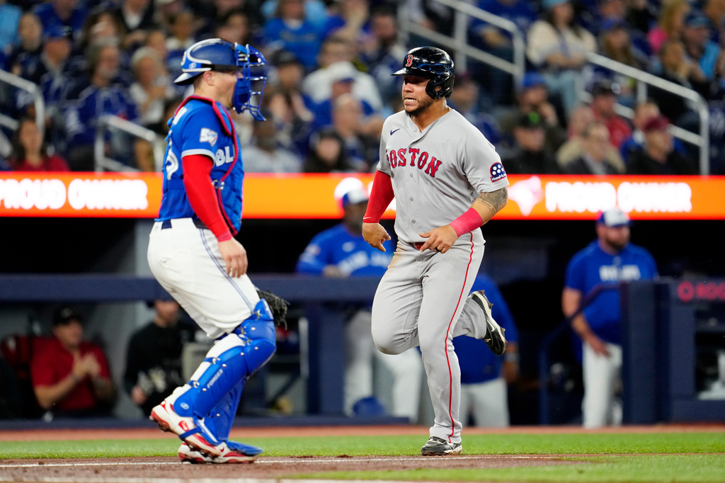 Boston Red Sox's Willson Contreras, right, scores on a single by teammate Marcelo Mayer as Toronto Blue Jays catcher Tyler Heineman, left, looks on during fourth-inning baseball game action in Toronto, Monday, April 27, 2026. (Frank Gunn/The Canadian Press via AP)