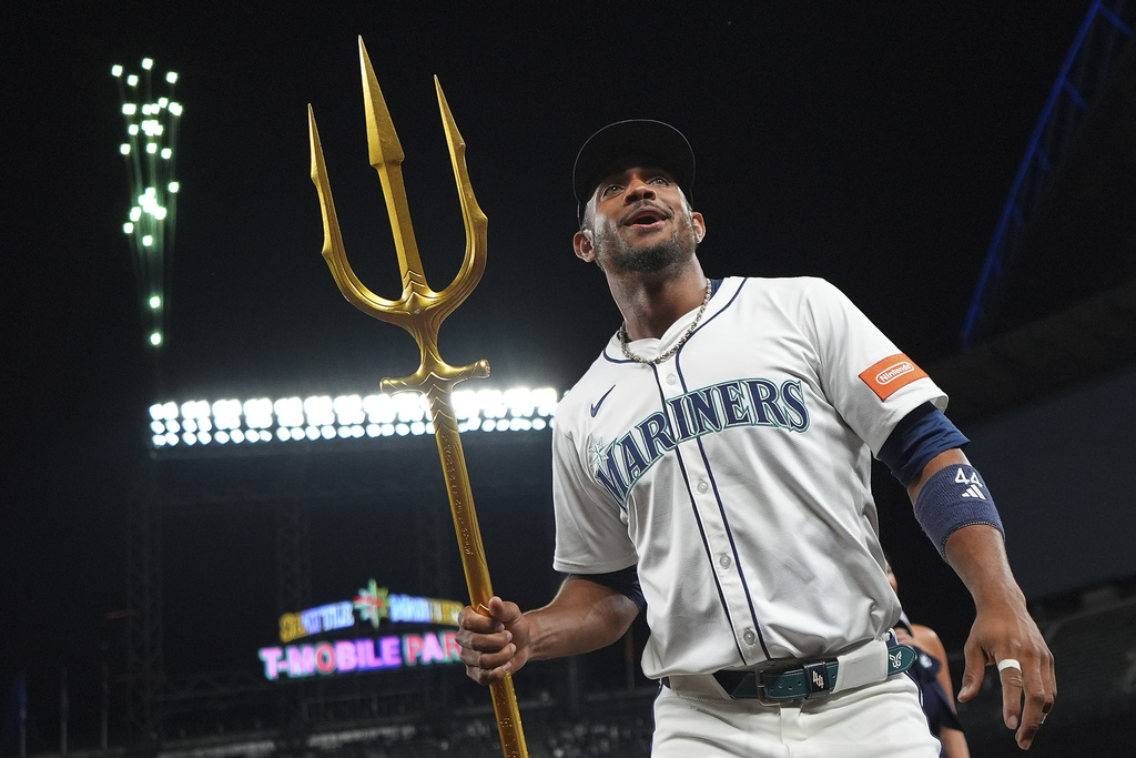 Seattle Mariners' Julio Rodriguez holds the trident to celebrate a win over the Tampa Bay Rays in a baseball game Saturday, Aug. 9, 2025, in Seattle. (AP Photo/Lindsey Wasson)