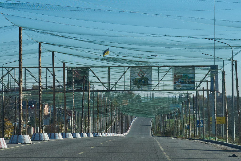 An empty road is covered with an anti-FPV-drone net at the approaches to the frontline city of Kherson, Southern Ukraine, Nov. 2, 2025. (AP Photo/Efrem Lukatsky)