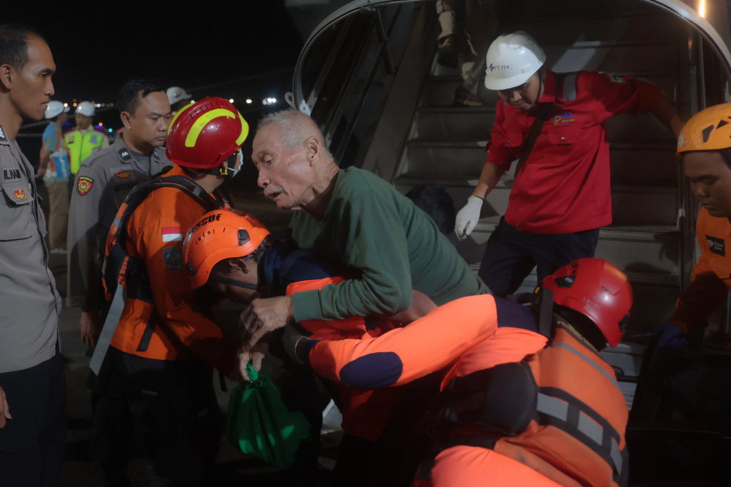 Rescuers assist a survivors of a ferry fire upon arrival at Tanjung Perak Port in Surabaya, East Java, Indonesia, Monday, Aug. 3, 2026. (AP Photo/Trisnadi)
