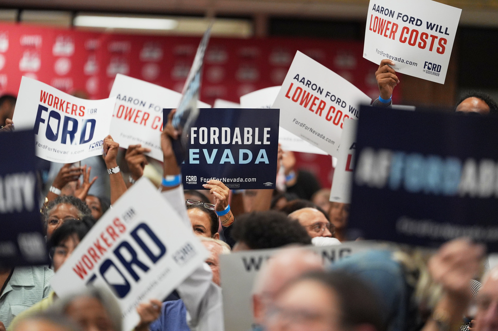 Attendees hold signs during a primary election night watch party for gubernatorial candidate Aaron Ford, attorney general of Nevada, Tuesday, June 9, 2026, in Las Vegas. (AP Photo/Jae C. Hong)