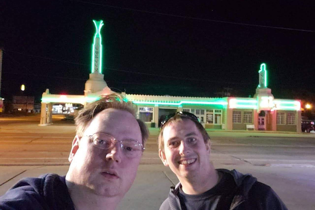 This photo provided by Faye Wurstner-Reagan shows her husband, Matthew Reagan, left, and her brother-in-law, Philip Reagan, during a stop at a Conoco Service Station in Shamrock, Texas, while the brothers journeyed to California in March of 2020. (Faye Wurstner-Reagan via AP)