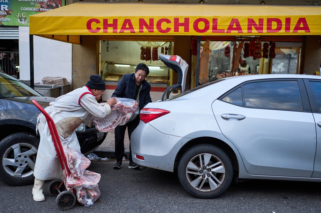 A worker loads pork and beef into a customer's trunk at the Mataderos meat market in Buenos Aires, Argentina, Thursday, May 14, 2026. (AP Photo/Rodrigo Abd)