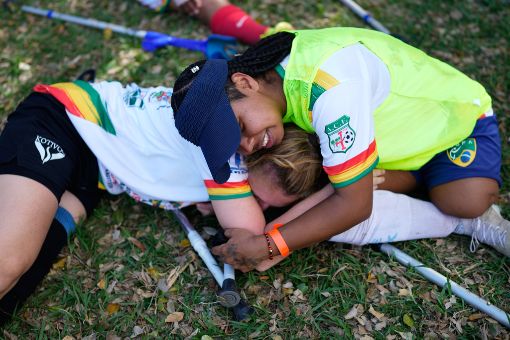 Players hug each other after playing during a women's amputee soccer clinic in Santa Cruz, Bolivia, Friday, July 17, 2026. (AP Photo/Juan Karita)