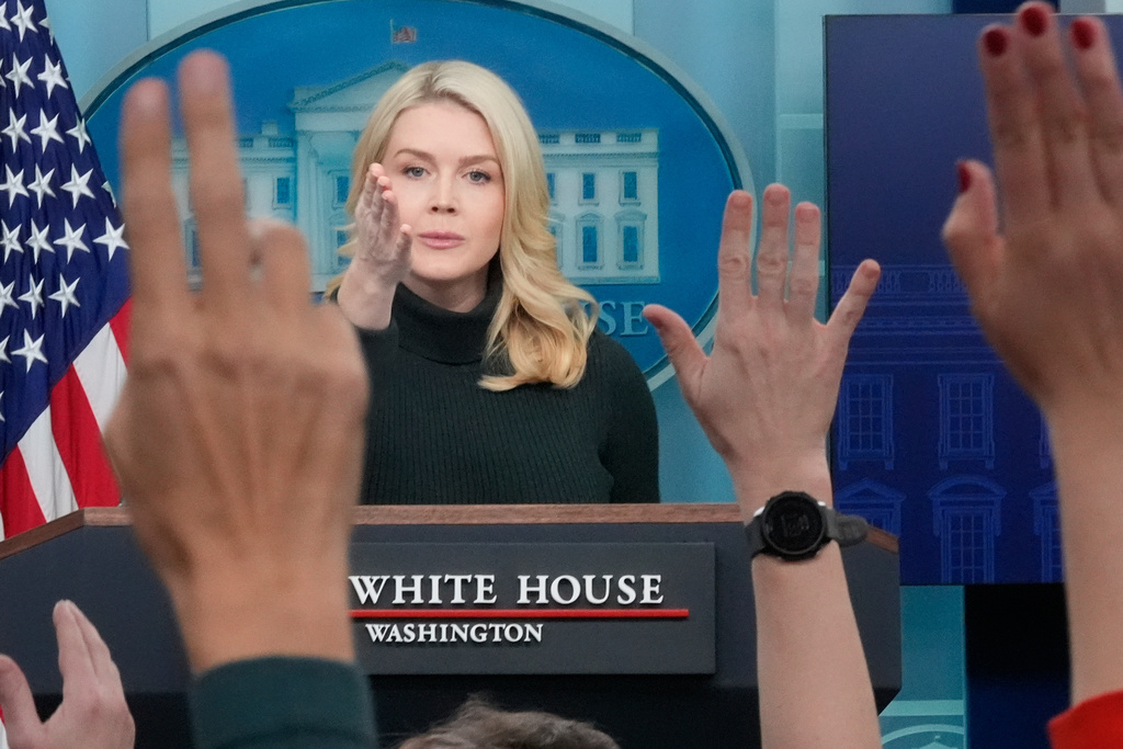 Reporters raise their hands to ask a question as White House press secretary Karoline Leavitt speaks with reporters in the James Brady Press Briefing Room at the White House, Monday, Jan. 26, 2026, in Washington. (AP Photo/Alex Brandon)