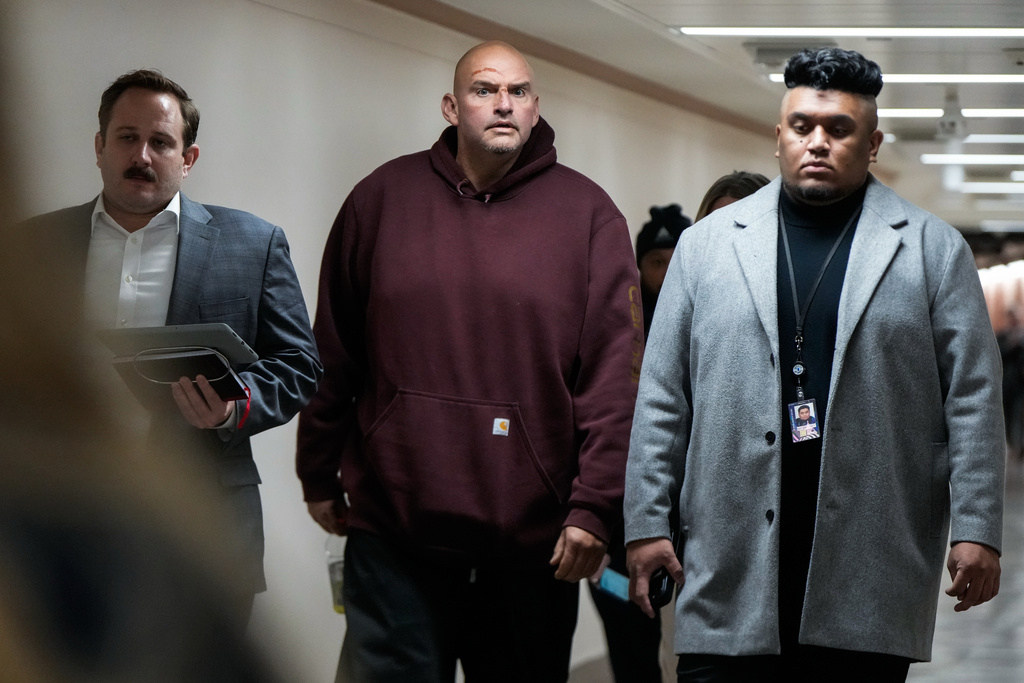 Injuries from a fall are seen on the face of Sen. John Fetterman, D-Pa., second from left, as he walks through a hallway on Capitol Hill, Wednesday, Nov. 19, 2025, in Washington. (AP Photo/Julia Demaree Nikhinson)