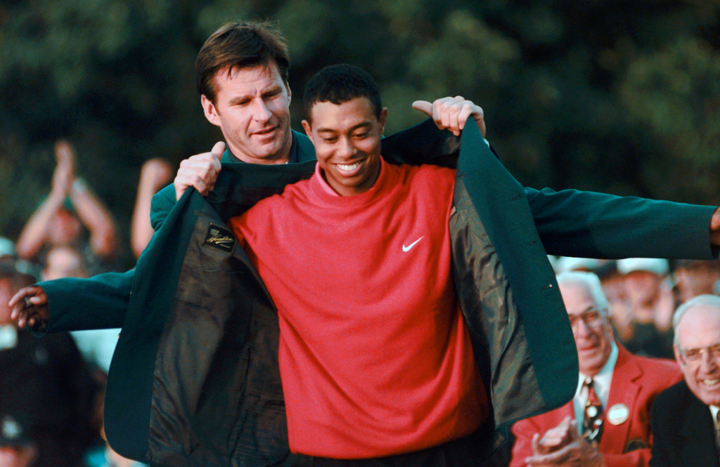 FILE - Masters champion Tiger Woods receives his Green Jacket from last year's winner Nick Faldo, left, at the Augusta National Golf Club, April 13, 1997, in Augusta, Ga. (AP Photo/ Dave Martin, File)