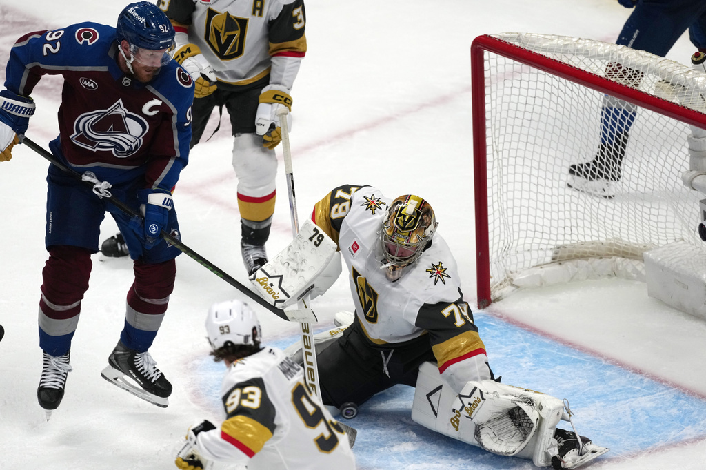 Vegas Golden Knights goaltender Carter Hart, right, stops a shot off the stick of Colorado Avalanche left wing Gabriel Landeskog during the third period in Game 1 of the Western Conference finals NHL hockey Stanley Cup playoff series Wednesday, May 20, 2026, in Denver. (AP Photo/David Zalubowski)