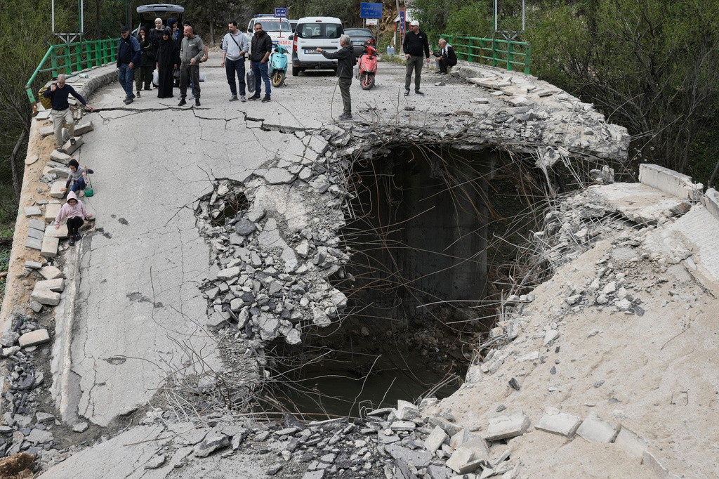 Displaced people walk across a destroyed bridge as they return to their villages, following a ceasefire between Hezbollah and Israel, in Tayr Felsay village, southern Lebanon, Sunday, April 19, 2026. (AP Photo/Bilal Hussein)