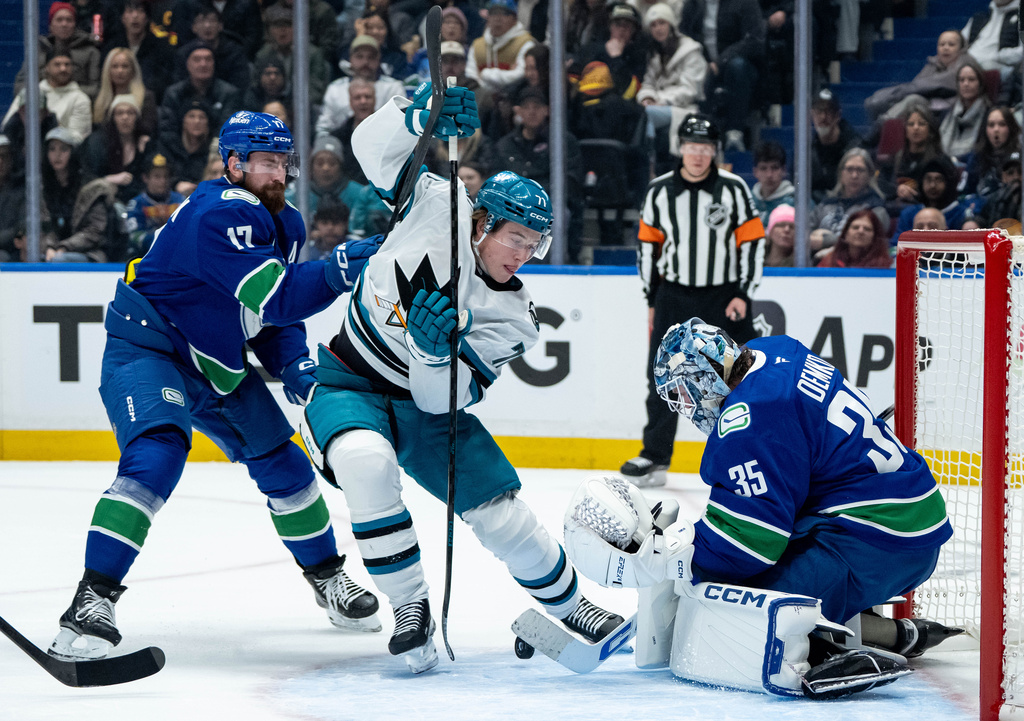 Vancouver Canucks goaltender Thatcher Demko (35) stops San Jose Sharks' Macklin Celebrini (71) as Canucks' Filip Hronek (17) defends during the first period of an NHL hockey game in Vancouver, British Columbia, Saturday, Dec. 27, 2025. (Ethan Cairns/The Canadian Press via AP)
