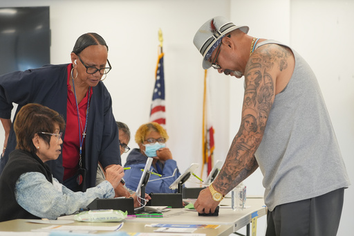 Los Angeles County Election officials assist first time voter Robert Conejo, right, as he votes in person on California's Proposition 50 election on Wednesday, Oct. 29, 2025, at the Los Angeles County Registrar-Recorder's headquarters in Norwalk, Calif. (AP Photo/Damian Dovarganes) Los Angeles County Election officials assist first time voter Robert Conejo, right, as he votes in person on California's Proposition 50 election on Wednesday, Oct. 29, 2025, at the Los Angeles County Registrar-Recorder's headquarters in Norwalk, Calif. (AP Photo/Damian Dovarganes)