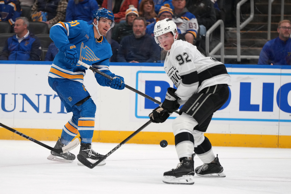 St. Louis Blues' Dylan Holloway (81) shoots past Los Angeles Kings' Brandt Clarke (92) during the second period of an NHL hockey game Tuesday, Oct. 21, 2025, in St. Louis. (AP Photo/Jeff Roberson)