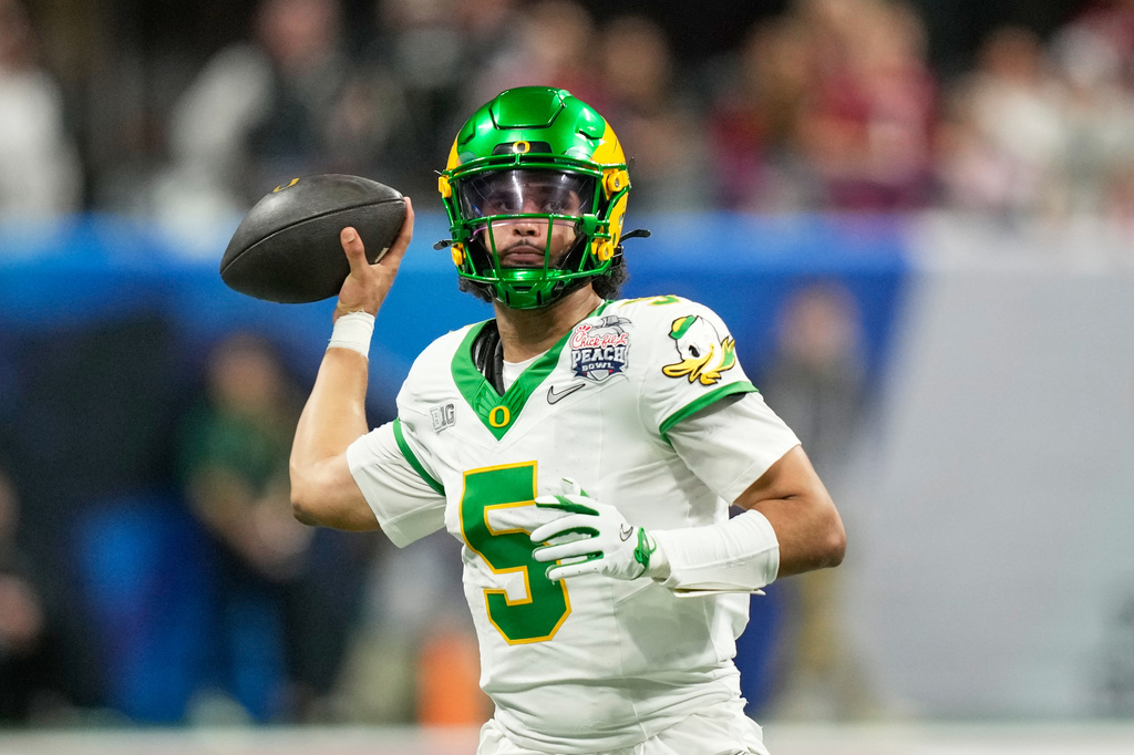 FILE - Oregon quarterback Dante Moore (5) throws a pass during the second half of the Peach Bowl NCAA college football playoff semifinal game against Indiana, Friday, Jan. 9, 2026, in Atlanta. (AP Photo/Brynn Anderson, File)