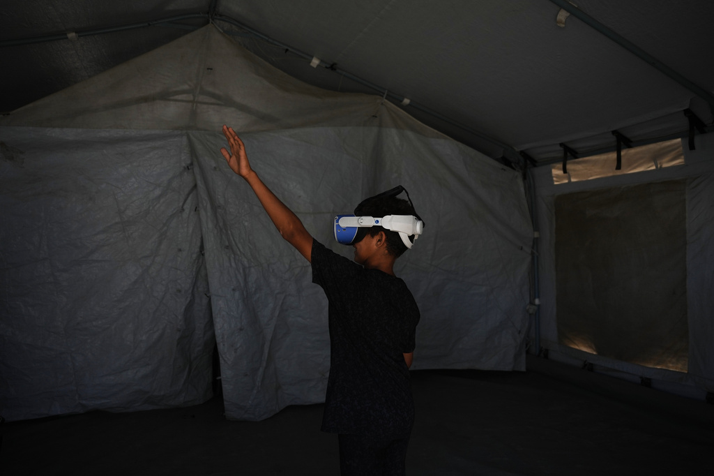 Mohammed Matar, 11, participates in a psychological support session using a virtual reality headset in a tent operated by a medical technology team in Zawaida, central Gaza Strip, Wednesday, June 17, 2026. (AP Photo/Abdel Kareem Hana)