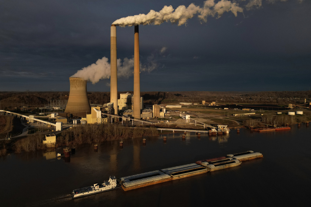 Barges of coal travel along the Ohio River past the coal-fired Mountaineer Power Plant, near New Haven, W.Va., Friday, March 13, 2026. (AP Photo/Carolyn Kaster)