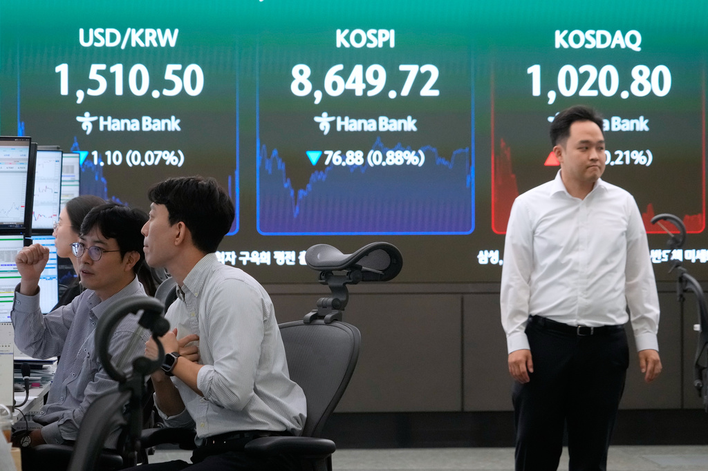 Currency traders work near a screen showing the Korea Composite Stock Price Index (KOSPI) and the foreign exchange rate between U.S. dollar and South Korean won at the foreign exchange dealing room of the Hana Bank headquarters in Seoul, South Korea, Wednesday, June 17, 2026. (AP Photo/Ahn Young-joon)