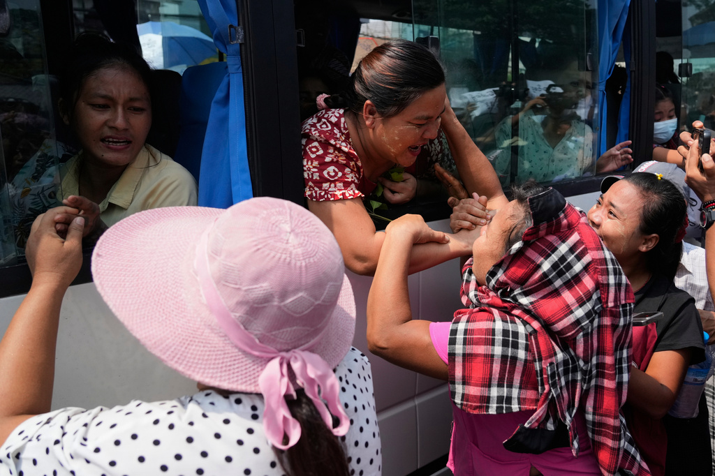 Released prisoners, in a bus, are welcomed by family members and colleagues after they left Insein Prison in Yangon, Myanmar, Friday, April 17, 2026, following Myanmar President's amnesty to mark the country's traditional new year. (AP Photo/Thein Zaw)