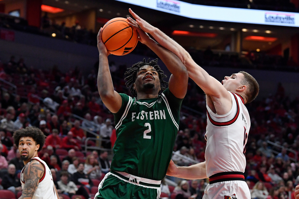 Louisville guard Isaac McKneely attempts to block the shot of Eastern Michigan guard Carlos Hart (2) during the first half of an NCAA college basketball game in Louisville, Ky., Monday, Nov. 24, 2025. (AP Photo/Timothy D. Easley)