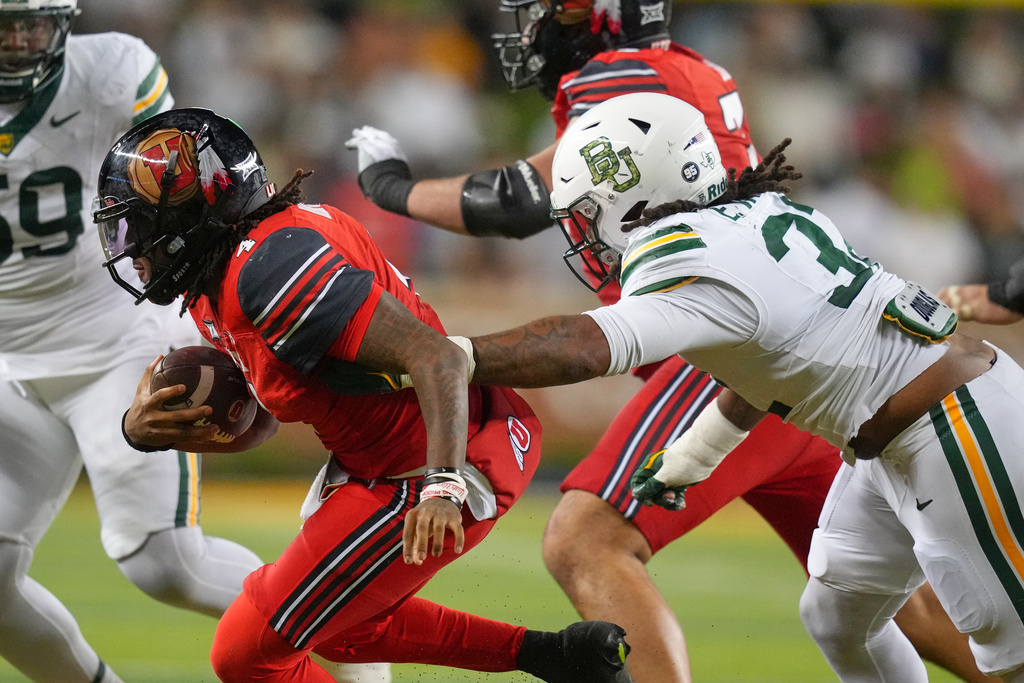 Utah quarterback Devon Dampier, left, is sacked by Baylor linebacker Emar'Rion Winston during the first half of an NCAA college football game Saturday, Nov. 15, 2025, in Waco, Texas. (AP Photo/Julio Cortez)